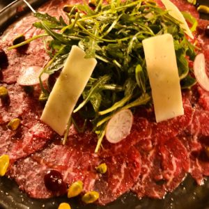 Beef carpaccio with arugula , Parmesan and pistachio